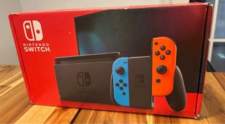 Nintendo Switch en caja con 4 controles