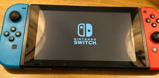 Nintendo Switch en caja con 4 controles