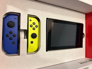 Nintendo Switch en caja con 4 controles