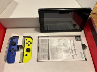 Nintendo Switch en caja con 4 controles
