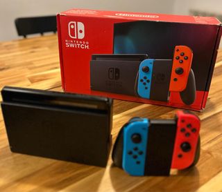 Nintendo Switch en caja con 4 controles