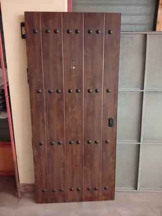 Puerta chapa madera oscura con remaches