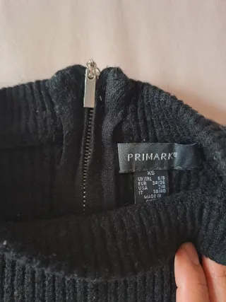 Jersey negro de punto con cremallera trasera.