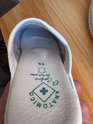 Zuecos blancos de enfermera de piel.