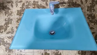 Lavabo de cristal azul con grifo