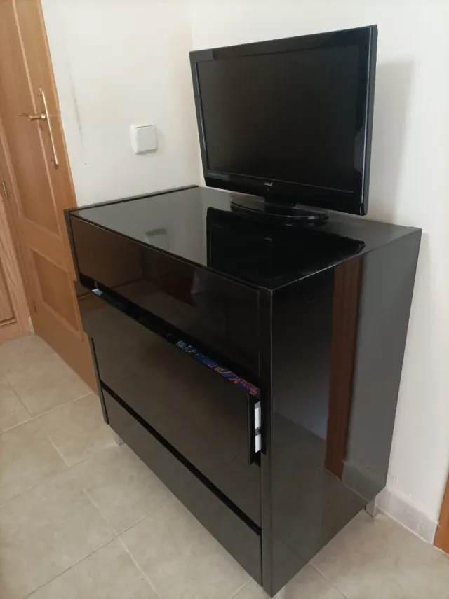 Cómoda negra lacada con superficie de cristal