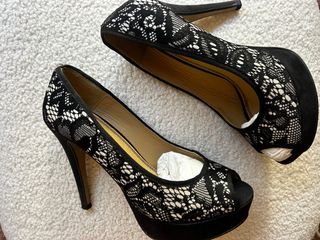 Zapatos tacón y bolso negros y blancos con encaje.