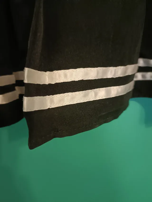 Falda corta negra plisada con rayas.