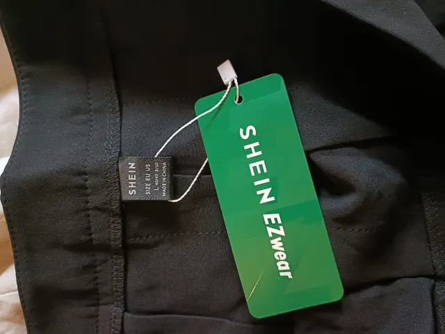 Falda corta negra plisada con rayas.