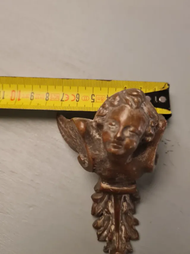 Adorno de bronce con ángel y hojas