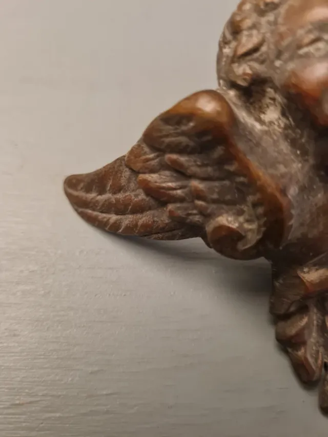 Adorno de bronce con ángel y hojas