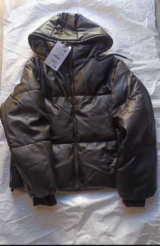 Abrigo negro efecto piel cuero con capucha.