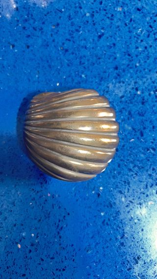 Pieza de latón con diseño de concha