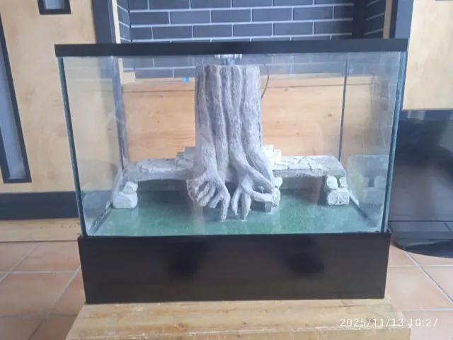 Pecera con decoración de roca y césped artesanal.