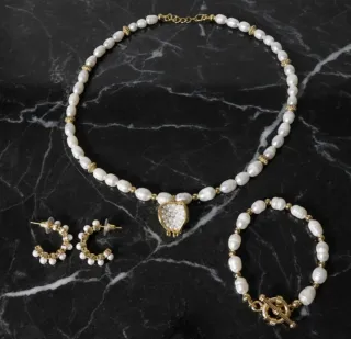 Conjunto de perlas con acabado dorado.