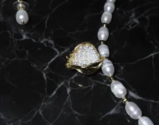 Conjunto de perlas con acabado dorado.