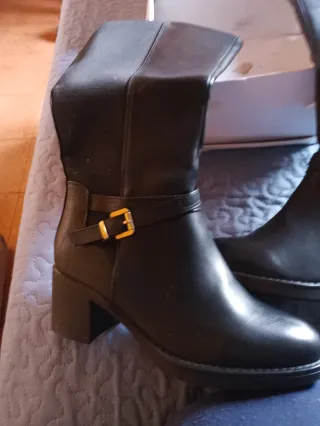 Botas altas negras con hebilla dorada