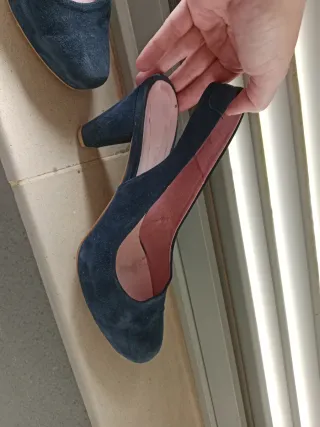 Zapatos de tacón azul marino destalonados.