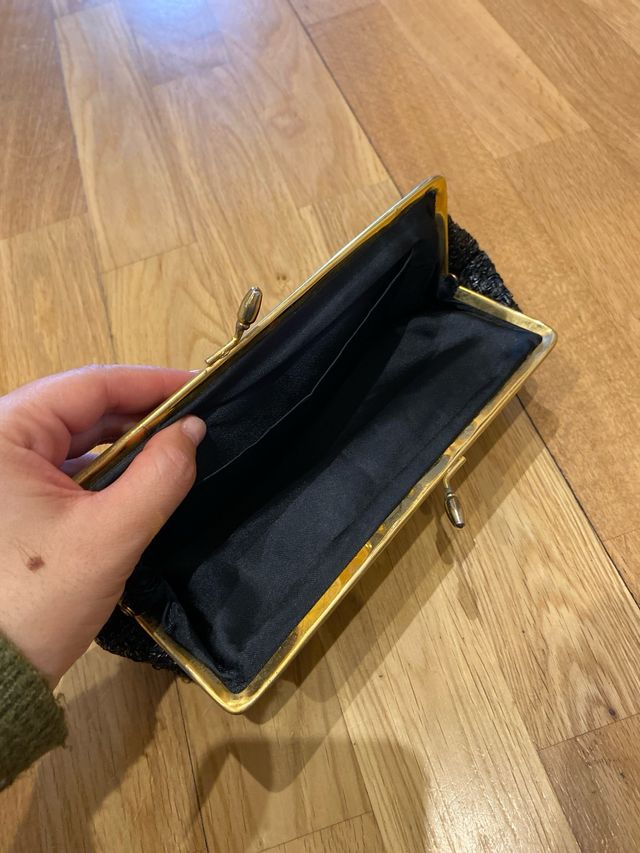 Cartera de mano negra y dorada