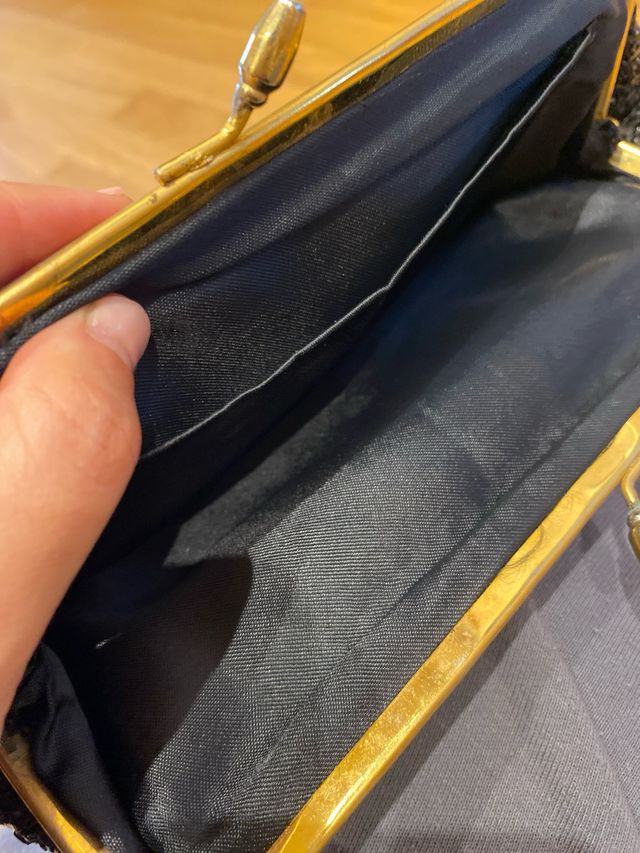 Cartera de mano negra y dorada