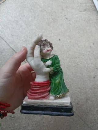 Figura niño con mano y tela roja