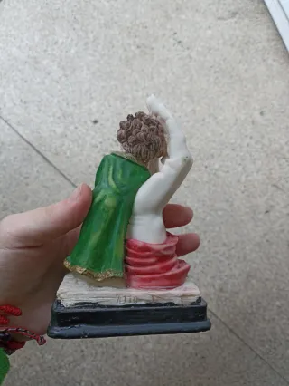 Figura niño con mano y tela roja