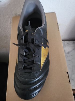 Botas de fútbol para niño negras y doradas.Mizuno