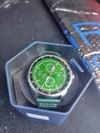 Reloj Skyline Verde y Plateado y Color oro.