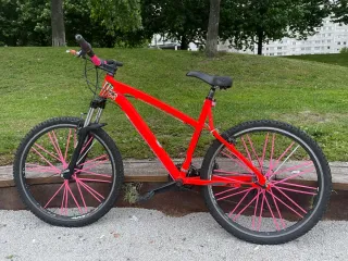 Bicicleta roja con ruedas rosas