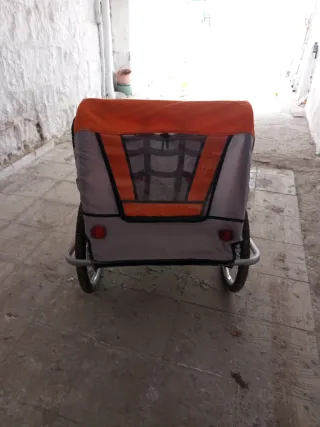Remolque para bicicleta naranja.