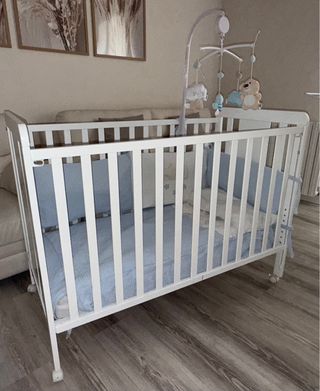 Cuna blanca con móvil y protector