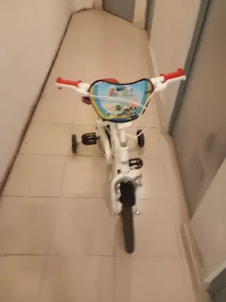 Bicicleta infantil blanca con ruedines