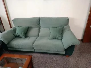 Sofá verde de tela y madera