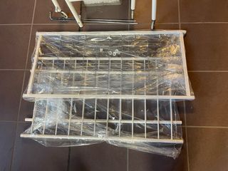 Cuna de bebé blanca con barrotes dorados