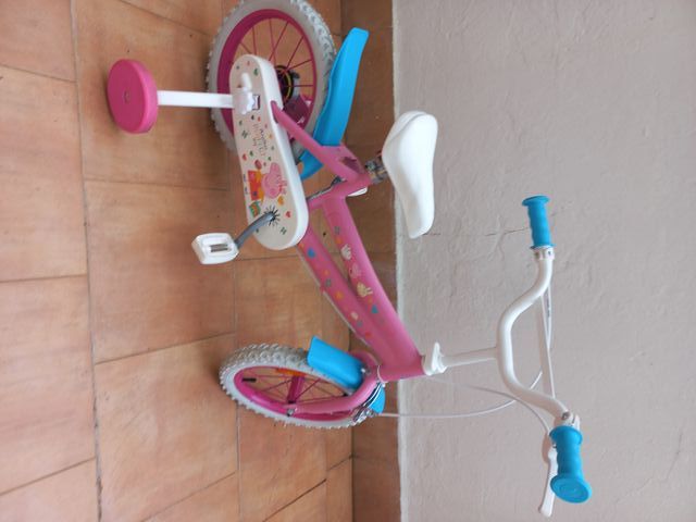 Bicicleta infantil rosa con ruedines