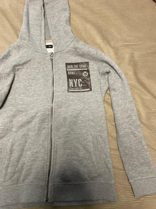 Sudadera gris con cremallera y estampado