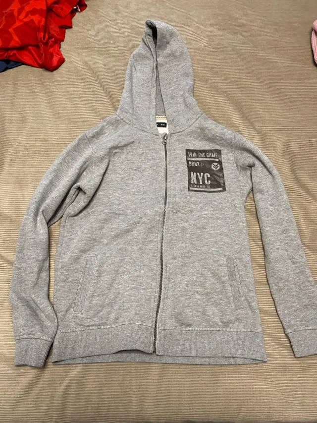 Sudadera gris con cremallera y estampado