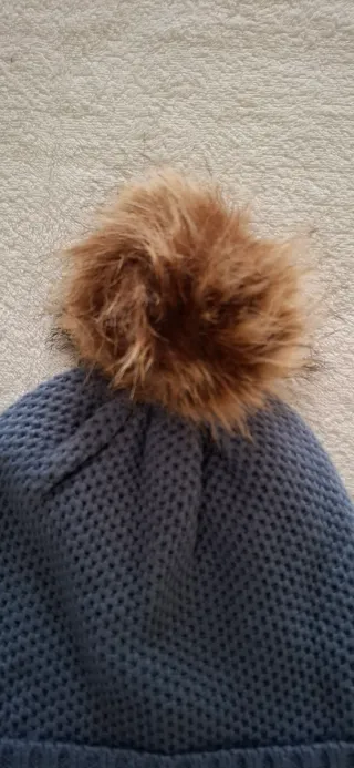 Berretto blu con pompon marrone