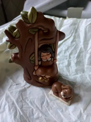 Thun bimba su altalena e cucciolo del presepe