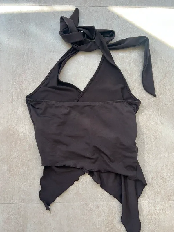 Top asimétrico con detalle dorado