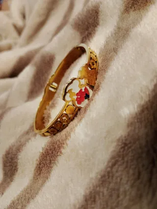 Pulsera dorada con diseño floral