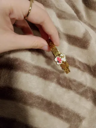 Pulsera dorada con diseño floral