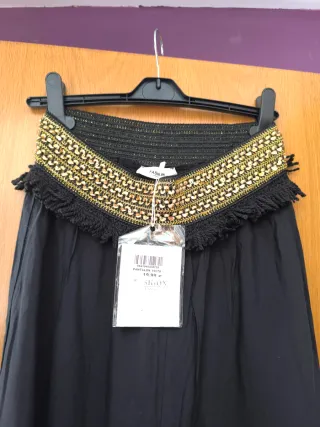 Pantalón negro caída ancho con detalles dorados