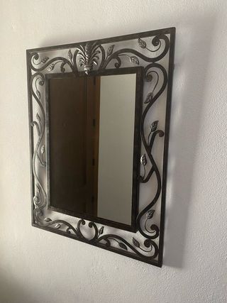 Espejo de metal con marco decorativo
