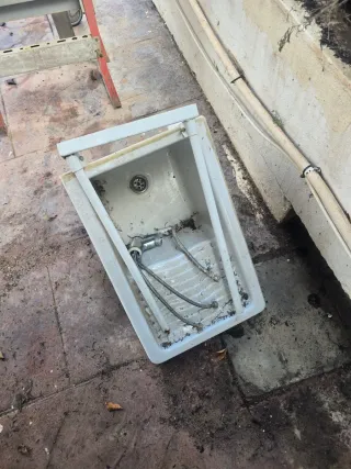 Fregadero de ceramica blanco con patas de hierro.