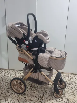 Cochecito de bebé beige con detalles dorados