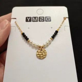 Gargantilla dorada con perlas y detalles negros