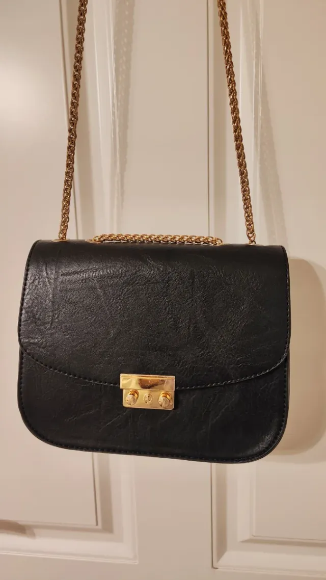 Bolso negro con cadena dorada
