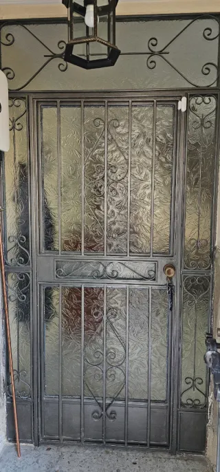 Puerta de entrada de forja con cristal