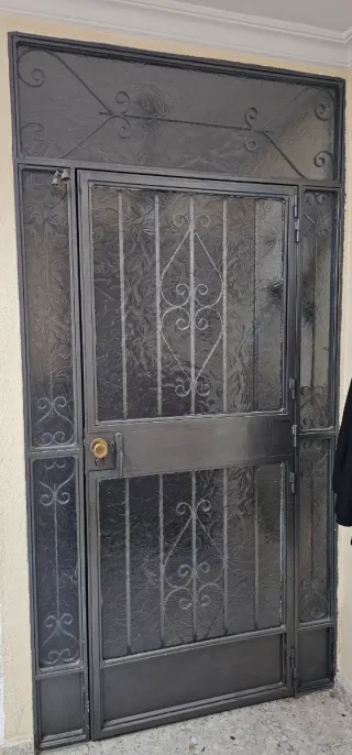 Puerta de entrada de forja con cristal